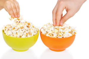 Hands of children eating popcorn